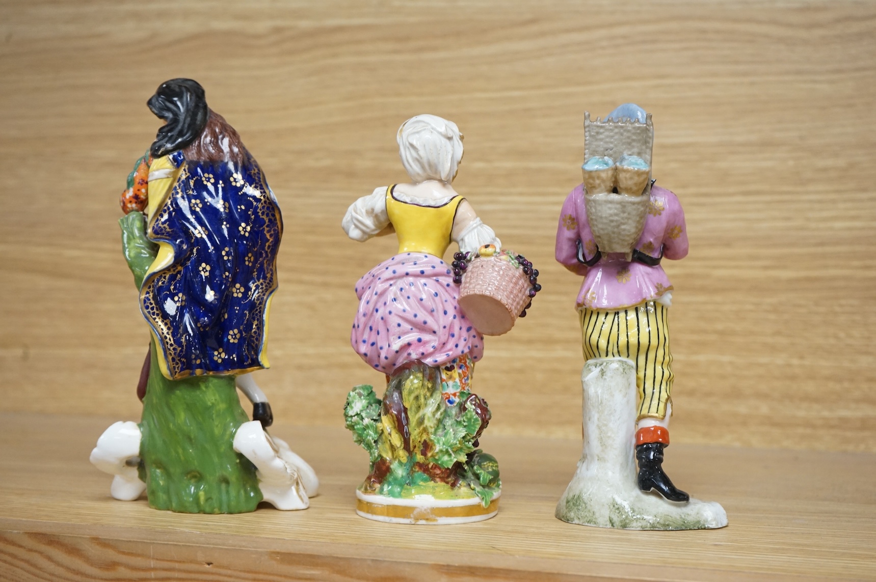 Three late 18th century Derby figures, a similar Derby figure of Summer, c.1810–30 and a Derby style figure of a street vendor, tallest 26cm high